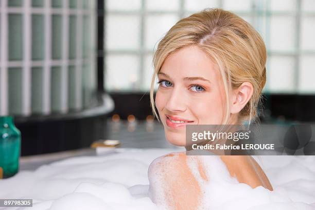 woman taking a bubble bath - bubble bath bottle stock pictures, royalty-free photos & images