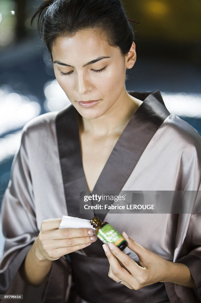 Woman holding a bottle of aromatherapy oil