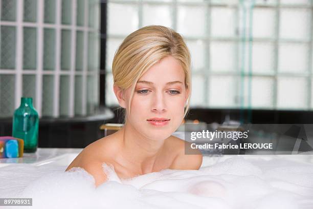 woman taking a bubble bath - bubble bath bottle stock pictures, royalty-free photos & images