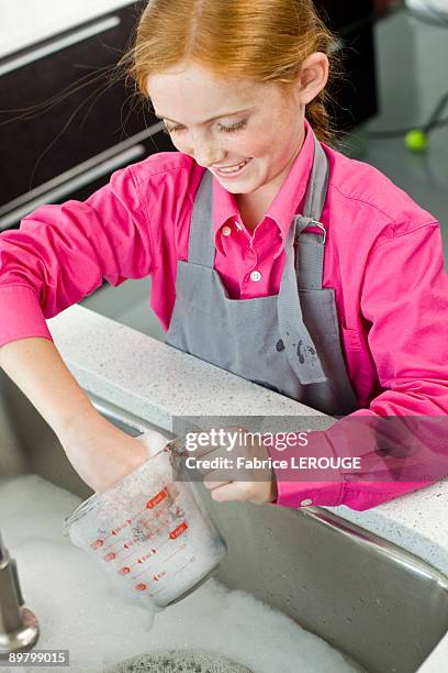 close-up of a girl washing a measuring jug at a sink - water in measuring cup stock pictures, royalty-free photos & images