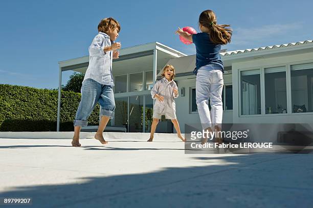 children playing with a ball - dreiviertel rückansicht stock-fotos und bilder