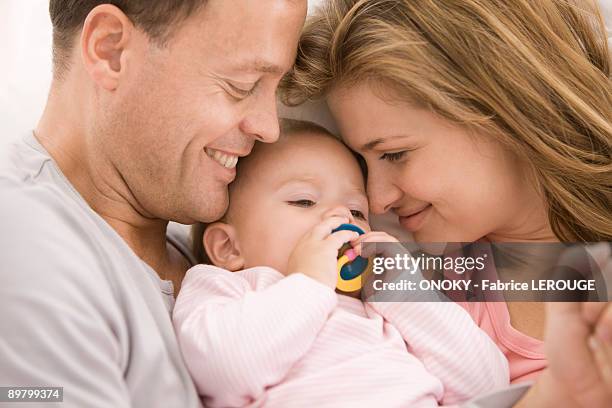 parents pampering their daughter - pacifier - fotografias e filmes do acervo