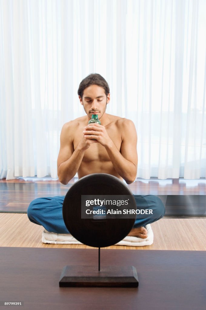 Man smelling aromatherapy oil from a bottle