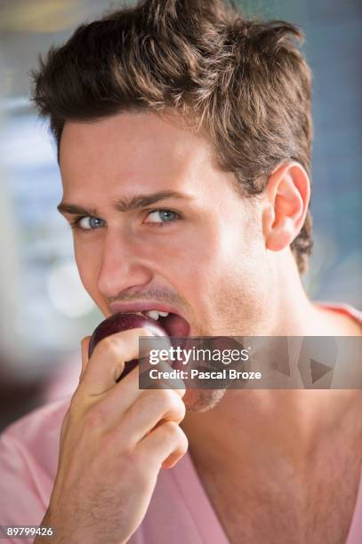 portrait of a man eating a nectarine - eating nectarine stock pictures, royalty-free photos & images
