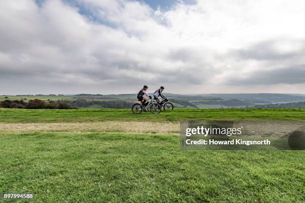 mature couple on mountain bikes in wide landscape - old howard fotografías e imágenes de stock