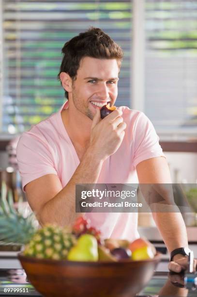 portrait of a man eating a nectarine - eating nectarine stock pictures, royalty-free photos & images