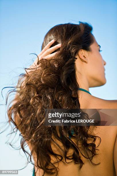 rear view of a woman with her hand in her hair - finger waves imagens e fotografias de stock