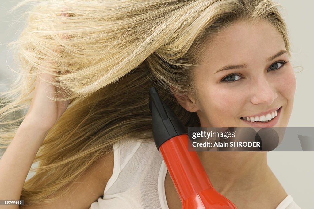 Woman drying her hair with a hair dryer