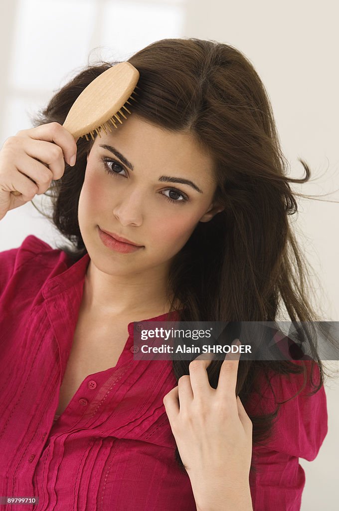 Portrait of a woman brushing her hair