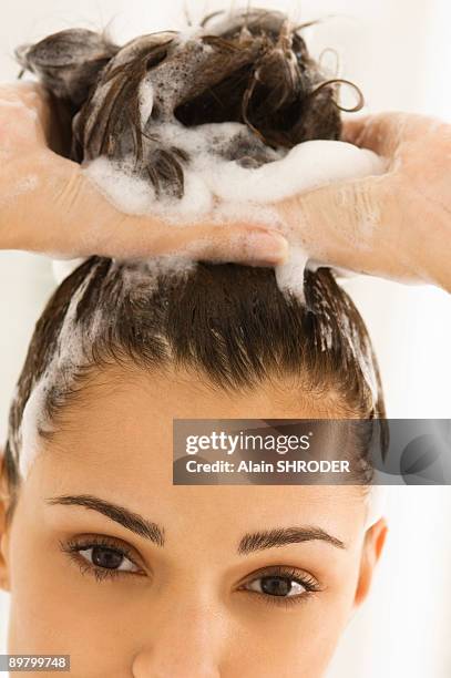 close-up of a woman shampooing her hair - femme shampoing photos et images de collection