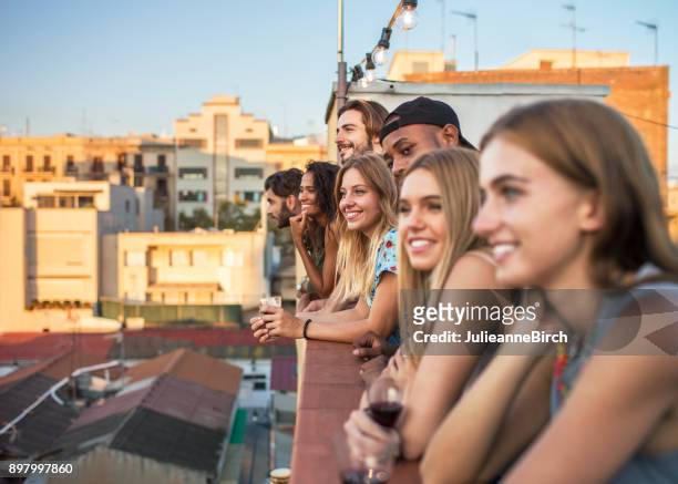 young diverse group of people on rooftop terrace watching dusk - barcelona skyline stock pictures, royalty-free photos & images