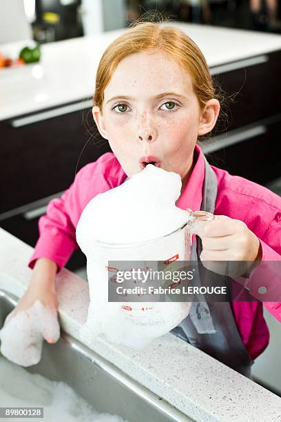 portrait of a girl blowing soap suds in a measuring jug - water in measuring cup stock pictures, royalty-free photos & images