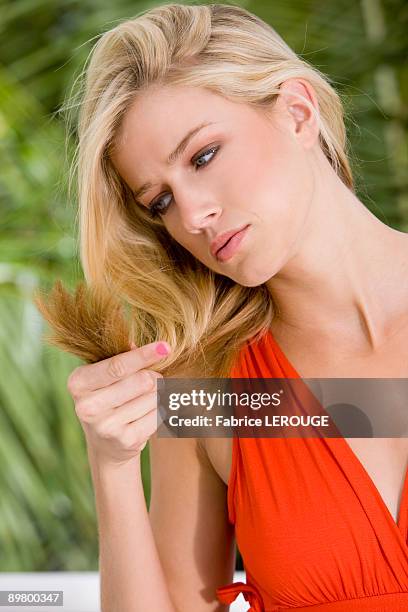 woman looking at her hair - damaged hair stock pictures, royalty-free photos & images