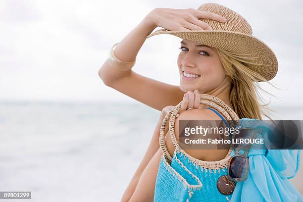 woman carrying a bag on the beach - sarong stock pictures, royalty-free photos & images