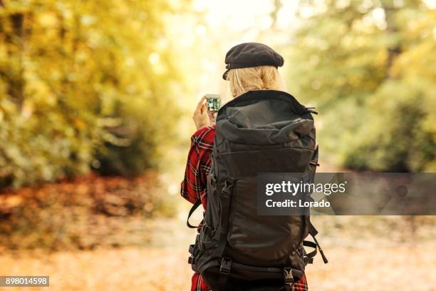 beautiful young blond female traveller walking in autumnal countryside setting in europe - gap year stock pictures, royalty-free photos & images