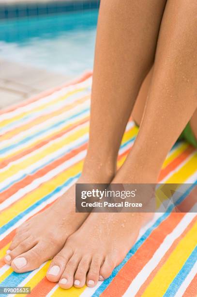 low section view of a woman sunbathing at the poolside - striped towel stock pictures, royalty-free photos & images