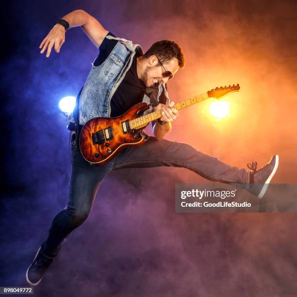 guitarist jumping on stage - guitarist stock pictures, royalty-free photos & images