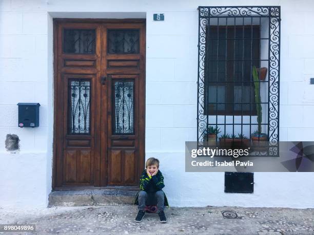 little boy resting in front of house - altea stock pictures, royalty-free photos & images