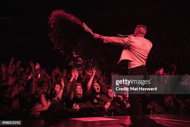 Rapper Macklemore sprays water from a bottle into the sold out crowd during his last US stop on the "Gemini" tour at KeyArena on December 23, 2017 in...