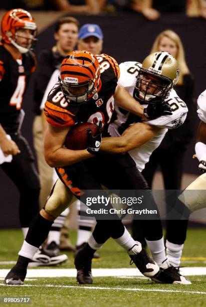 Tight end Chase Coffman of the Cincinnati Bengals is tackled by linebacker Scott Fujita of of the New Orleans Saints during a preseason game on...