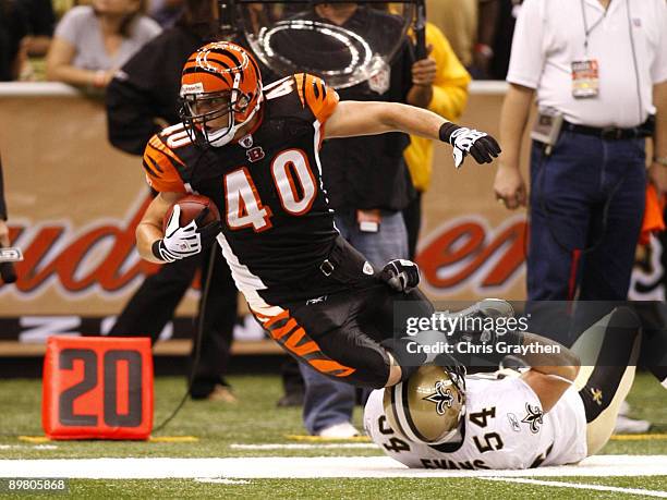 Running back Brian Leonard of the Cincinnati Bengals is tackled by linebacker Troy Evans of the New Orleans Saints during the preseason game on...