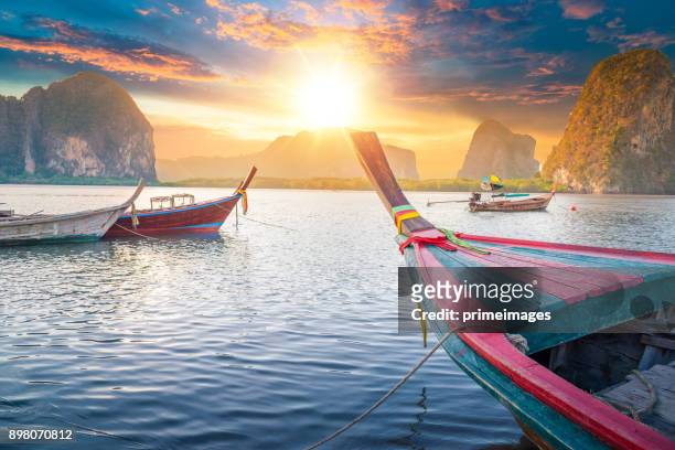 hermosa puesta de sol en el mar tropical con larga cola en bote en el sur de tailandia - krabi fotografías e imágenes de stock