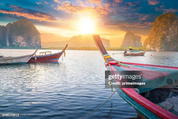 prachtige zonsondergang op tropische zee met lange staart boot in zuid-thailand - longtailboot stockfoto's en -beelden