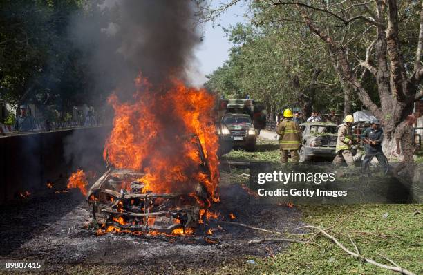 Car is engulfed in flames after a suicide car bomb exploded near the main gate of the NATO headquarters, killing three Afghans and wounding 70, on...