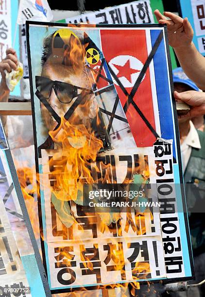 South Korean conservative activists burn a placard bearing the face of North Korea's leader Kim Jong-il during an anti-North Korea rally in Seoul on...