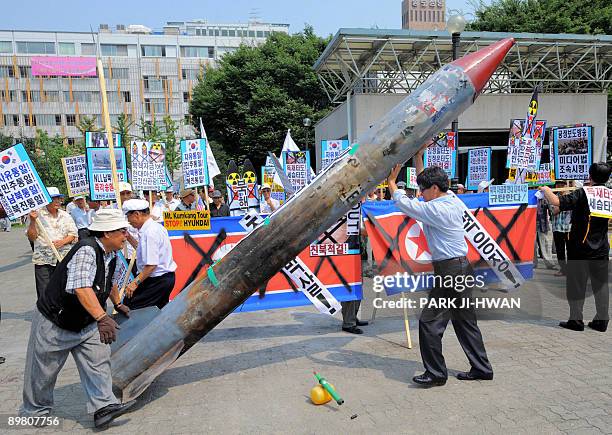 South Korean conservative activists carry a mock North Korean missile during an anti-North Korea rally in Seoul on August 15, 2009. South Korean...