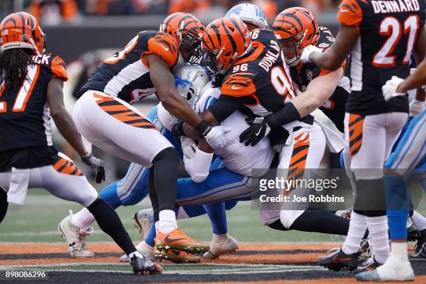 George Iloka and Carlos Dunlap of the Cincinnati Bengals combine to tackle Theo Riddick of the Detroit Lions during the first half at Paul Brown...
