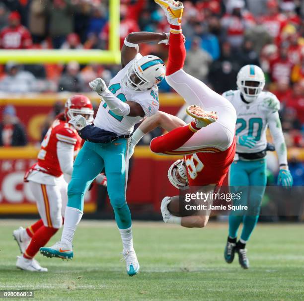 Tight end Travis Kelce of the Kansas City Chiefs gets flipped upside down after leaving his feet on a tackle by defensive back Alterraun Verner of...