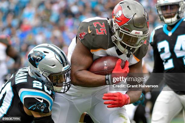 Peyton Barber of the Tampa Bay Buccaneers runs the ball against the Carolina Panthers in the first quarter at Bank of America Stadium on December 24,...