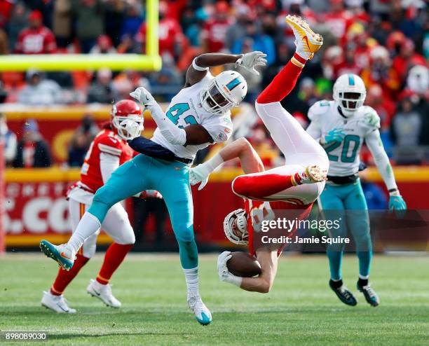 Tight end Travis Kelce of the Kansas City Chiefs is upended by defensive back Alterraun Verner of the Miami Dolphins after making a catch during the...