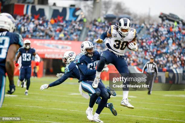 Running Back Todd Gurley II of the Los Angeles Rams carries the ball against Safety Kevin Byard and Linebacker Wesley Woodyard of the Tennessee...