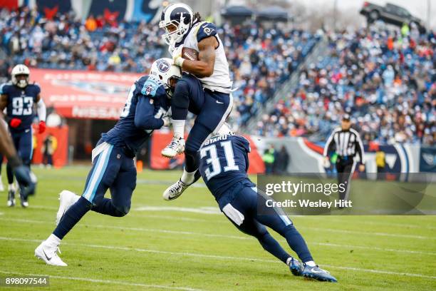 Running Back Todd Gurley II of the Los Angeles Rams carries the ball against Safety Kevin Byard and Linebacker Wesley Woodyard of the Tennessee...