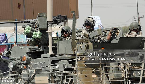 Soldiers patrol in their vehicles on a street in Kandahar on August 15, 2009. Presidential race heavy-hitters jetted across Afghanistan to win votes...