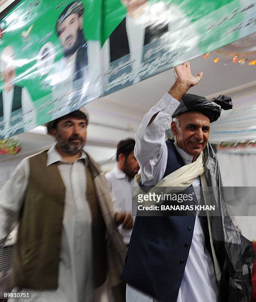 Afghan presidential candidate Ashraf Ghani Ahmadzai waves to supporters during an election campaign meeting in Kandahar on August 15, 2009....