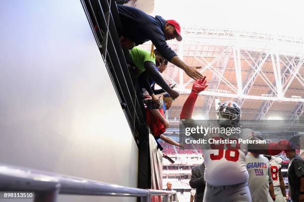 Defensive tackle Damon Harrison of the New York Giants high fives fans as he walks off the field before the NFL game against the Arizona Cardinals at...
