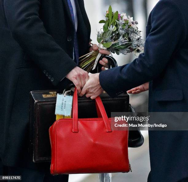 Queen Elizabeth II's police protection officers carry her bags and briefcase as she and Prince Philip, Duke of Edinburgh arrive at King's Lynn...