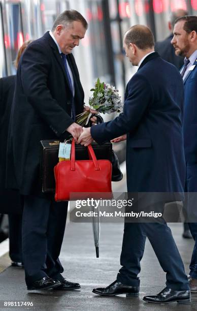 Queen Elizabeth II's police protection officers carry her bags and briefcase as she and Prince Philip, Duke of Edinburgh arrive at King's Lynn...