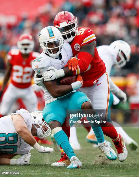 Running back Kenyan Drake of the Miami Dolphins is stopped by nose tackle Bennie Logan of the Kansas City Chiefs during the game at Arrowhead Stadium...