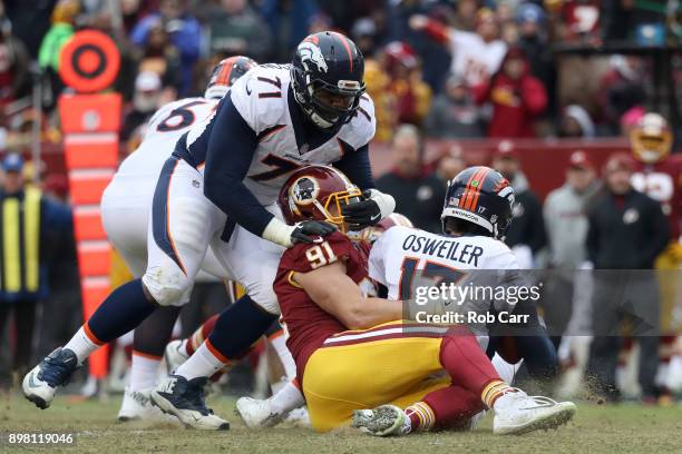 Offensive tackle Donald Stephenson of the Denver Broncos attempt to block outside linebacker Ryan Kerrigan of the Washington Redskins as he sacks...