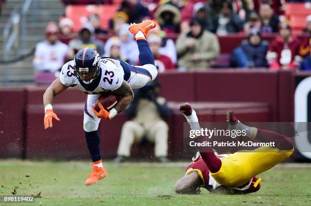 Running back Devontae Booker of the Denver Broncos is upended by linebacker Pete Robertson of the Washington Redskins in the fourth quarter at...