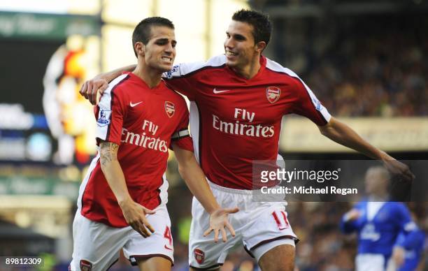 Francesc Fabregas of Arsenal is congratulated by teammate Robin van Persie after scoring his team's fourth goal during the Barclays Premier League...