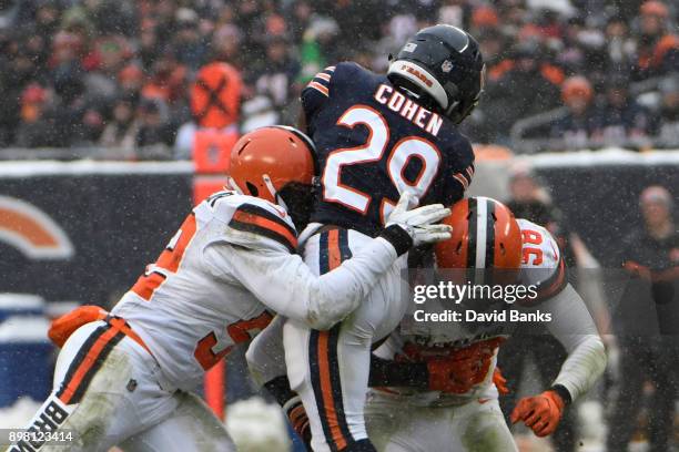 Tarik Cohen of the Chicago Bears is hit by James Burgess and Christian Kirksey of the Cleveland Browns in the third quarter at Soldier Field on...