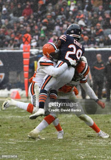 Tarik Cohen of the Chicago Bears is hit by James Burgess and Christian Kirksey of the Cleveland Browns in the third quarter at Soldier Field on...