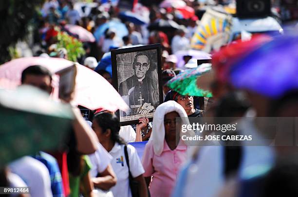 Catholic faithfuls participate in a march to celebrate the 92nd birthday of the late archbishop of San Salvador, Oscar Arnulfo Romero, carrying...