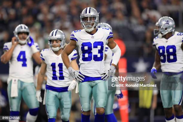 Wide receivers Cole Beasley, Terrance Williams, and Dez Bryant of the Dallas Cowboys walk to the sidelines in the first quarter of a football game...