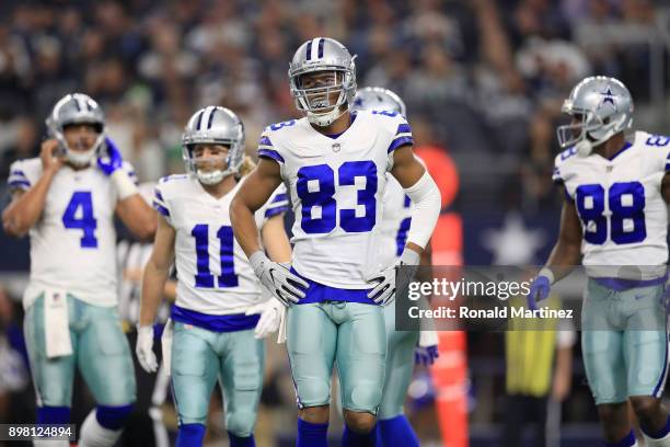 Wide receivers Cole Beasley, Terrance Williams, and Dez Bryant of the Dallas Cowboys walk to the sidelines in the first quarter of a football game...